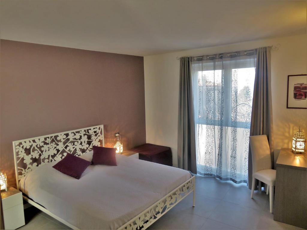 a bedroom with a large bed and a large window at Al dolce eremo in Trieste