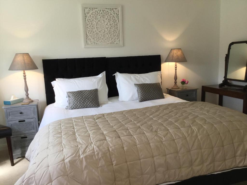 a bedroom with a large white bed with two lamps at Little Owl Barn in Marlborough