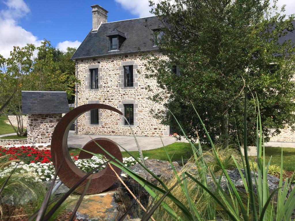 Clos l'Abbe, Piscine & Spa - Demeure de Prestige في Ouville: بيت حجري امامه تمثال