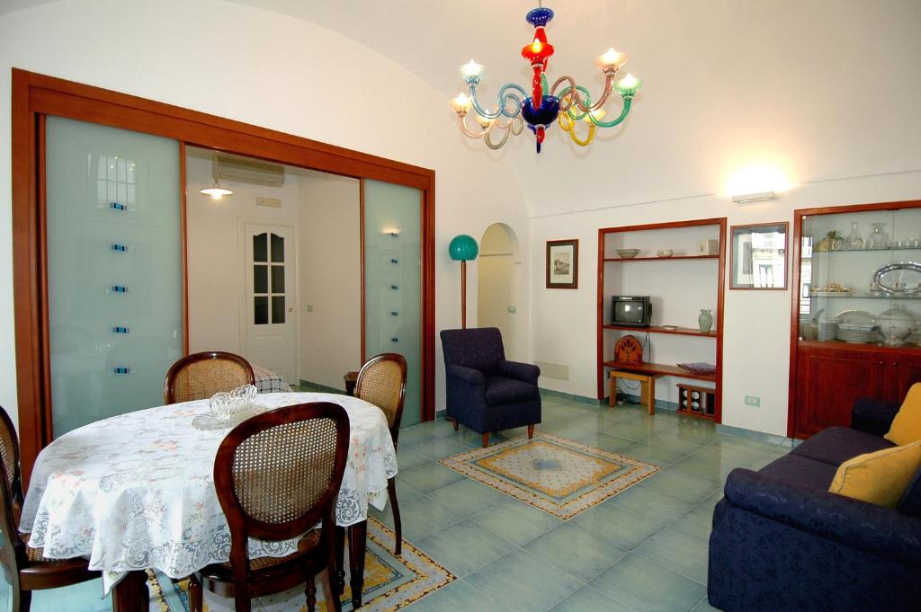 comedor con mesa, sillas y lámpara de araña en Quattro Passi, en Amalfi