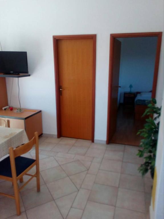 a room with a door and a table and a chair at Apartments Irena in Božava