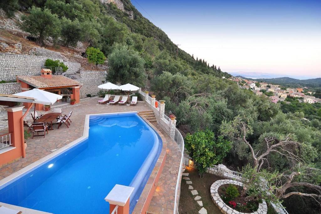 a swimming pool in front of a house with a mountain at Nel Verde in Skripero in Skriperón