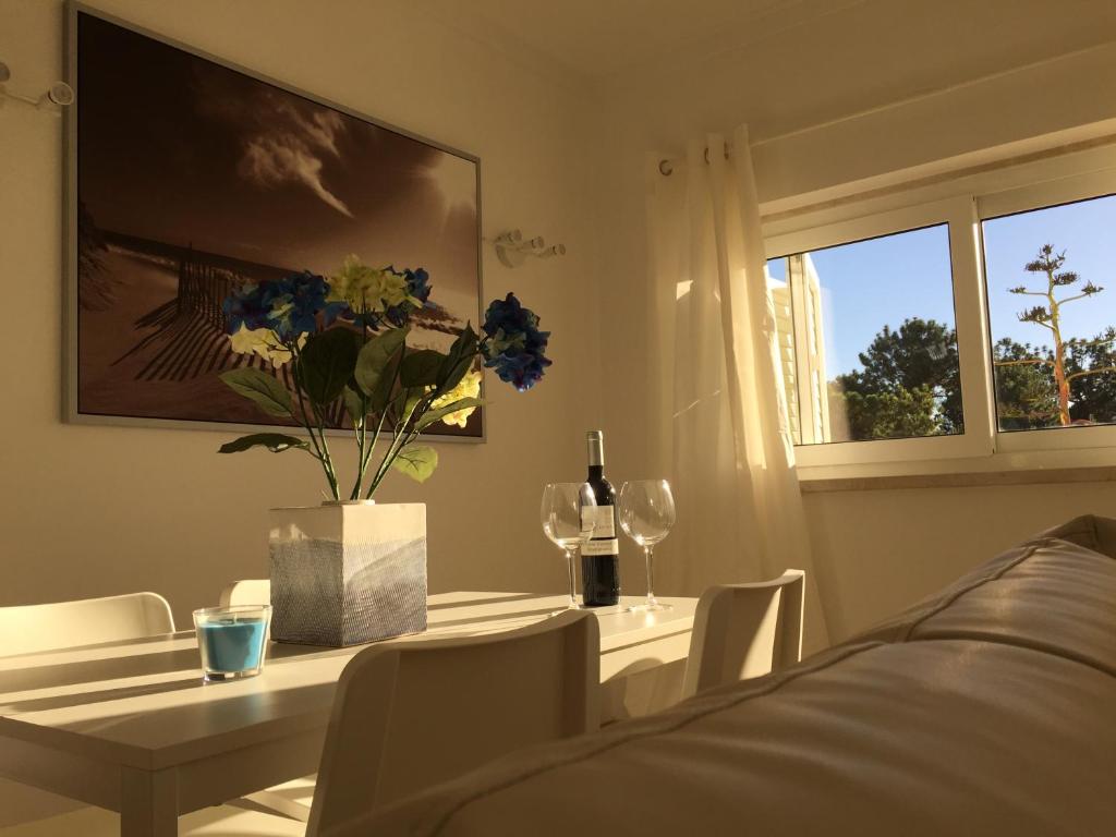 uma sala de jantar com uma mesa com um vaso de flores em SolTroia Glamorous Apartament em Troia