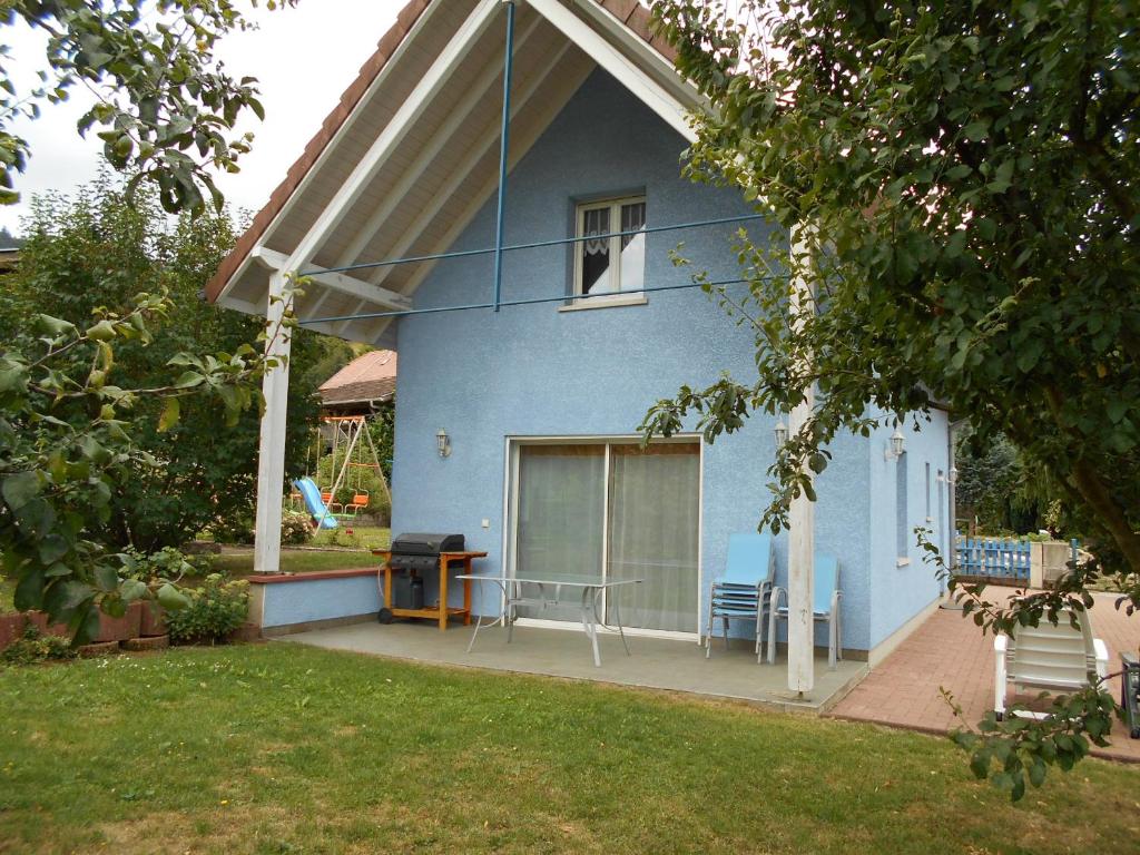 a blue house with a table and chairs in a yard at LA MAISON EN PAIN D'EPICES in Sainte-Marie-aux-Mines