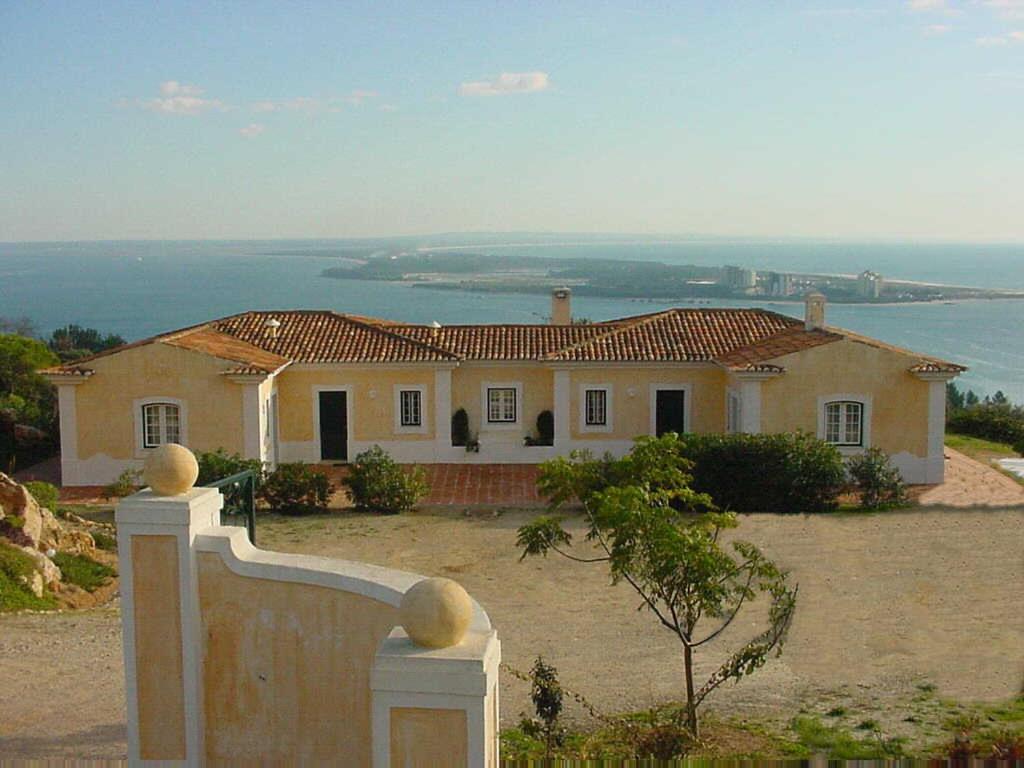 ein Haus auf einem Hügel mit dem Ozean im Hintergrund in der Unterkunft Ha Mar ao Luar in Setúbal
