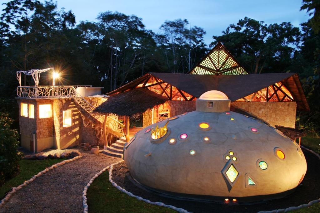 a house with a large sphere in the yard at Tree House Lodge in Puerto Viejo