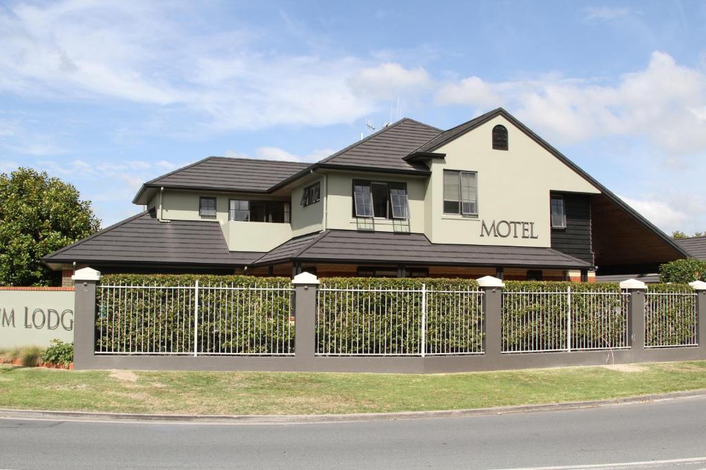 uma casa com um telhado preto e uma cerca em Quantum Lodge Motor Inn em Hamilton