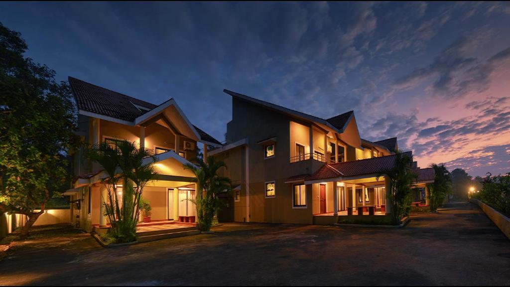 a large house with lights on in the night at TreeHouse Blue Hotel & Villas in Colva