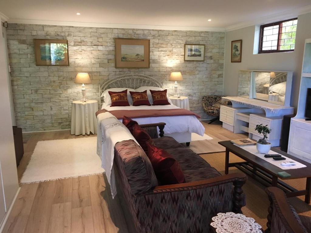 - une chambre avec un lit et un canapé dans l'établissement Geranium Studio, à Somerset West