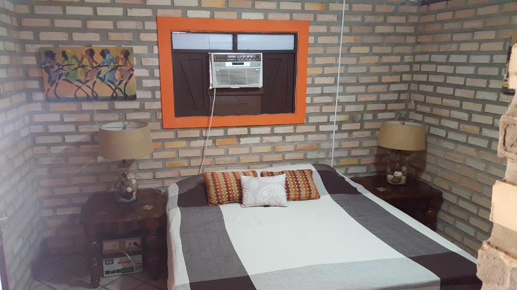 a bedroom with a bed and a window and two lamps at Chales Jack & Jill in Pipa