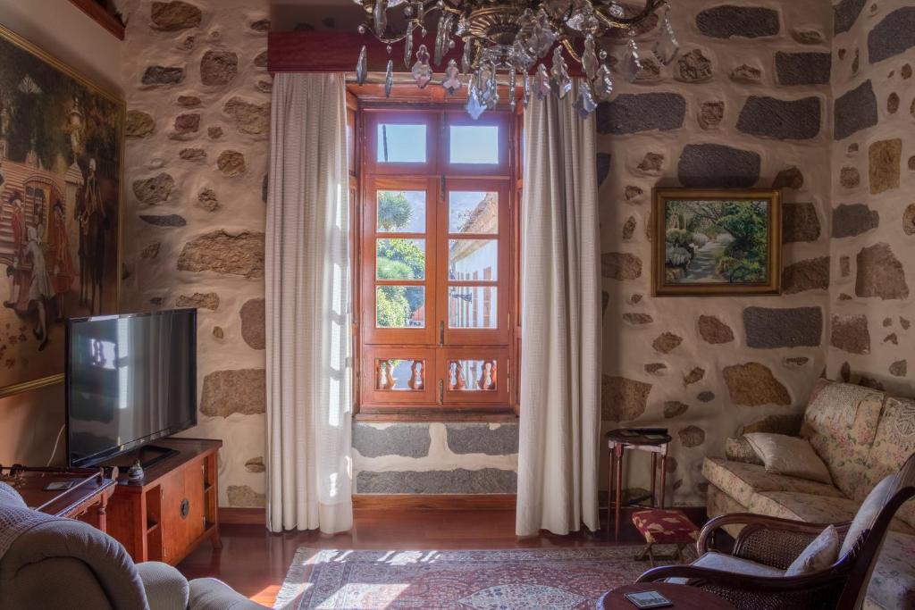 a living room with a tv and a window at Casa Rural Doña Margarita in Teror