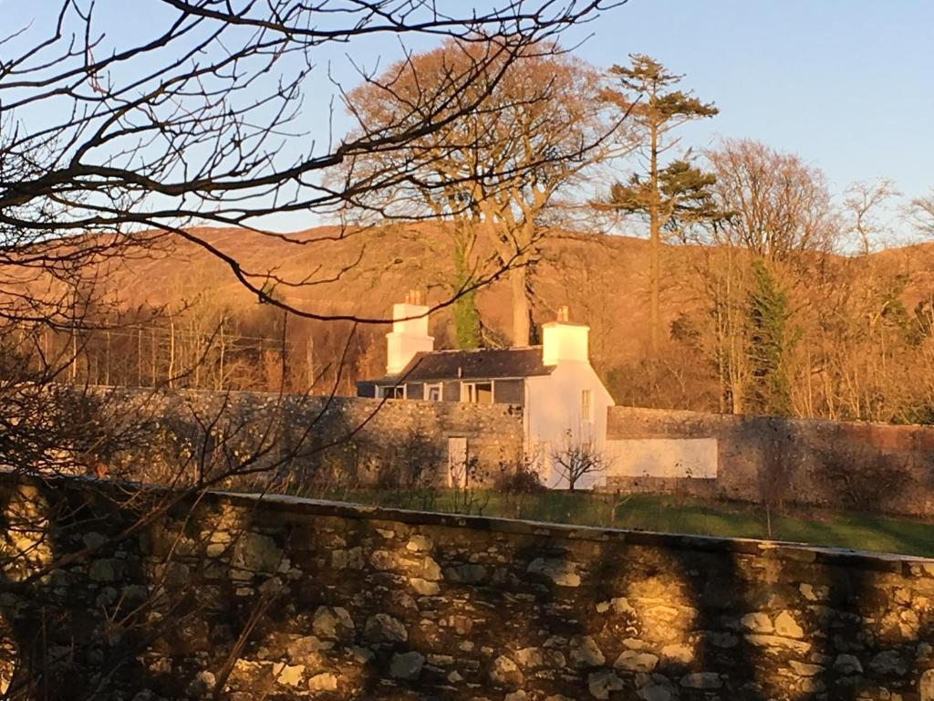 CarsluithにあるGarden Cottageの石垣の上に座る家