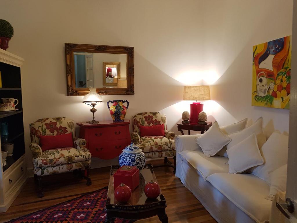 un soggiorno con divano, sedie e specchio di Casa Mackenna a Valparaíso