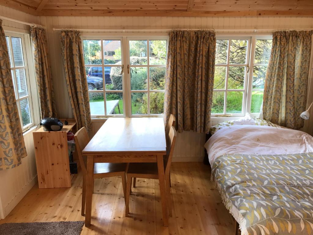 a bedroom with a table and a bed and windows at Crabapple Cottage B&B in Lewes