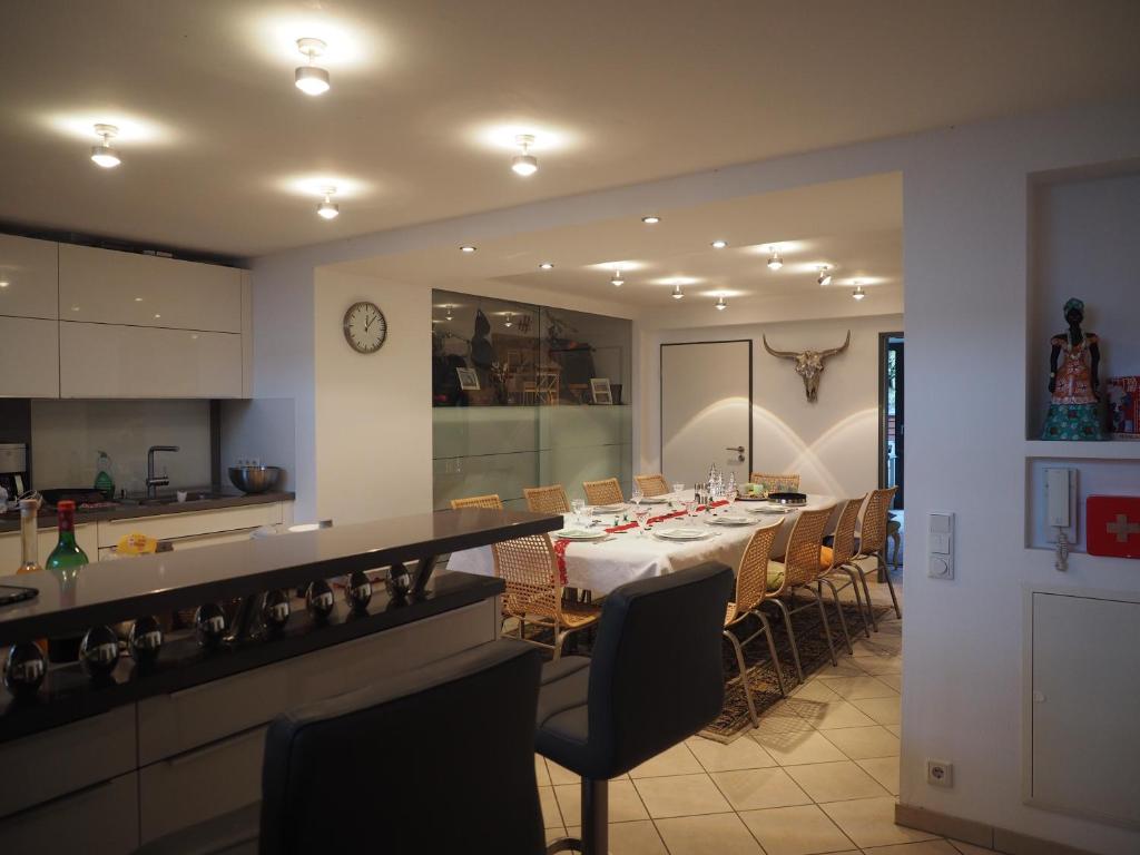 a dining room with a long table and a kitchen at B8 - just a private accommodation in Düsseldorf