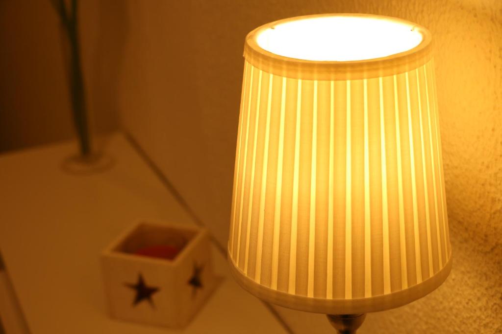 una lámpara amarilla en una mesa junto a un reloj en Sweet House en Lisboa