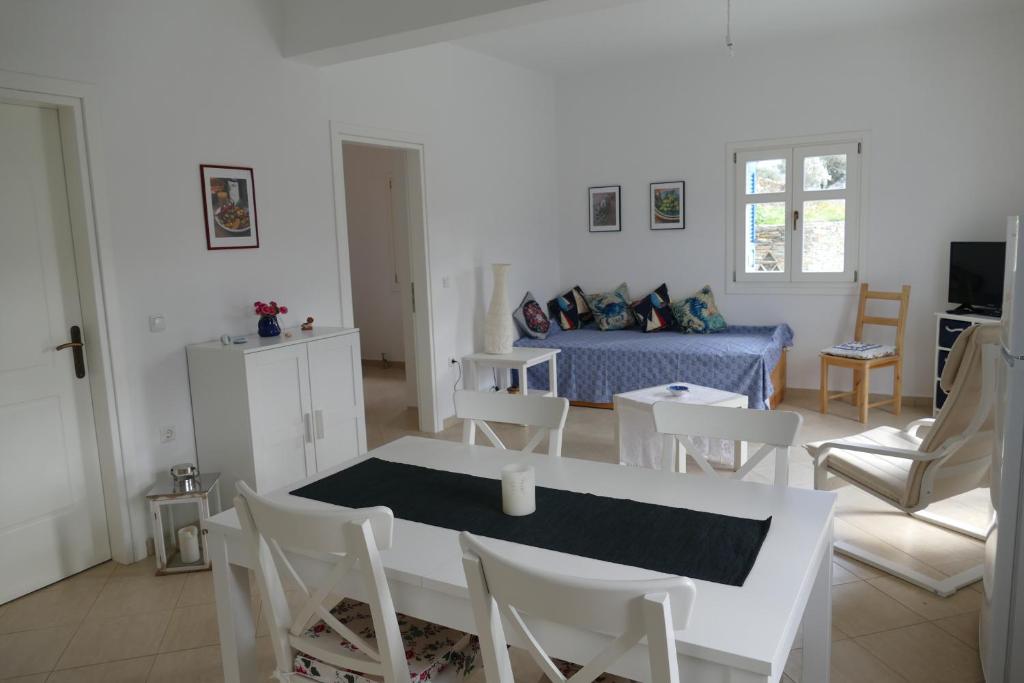 ein weißes Wohnzimmer mit einem Tisch und Stühlen in der Unterkunft Villa Gabriela in Rogón