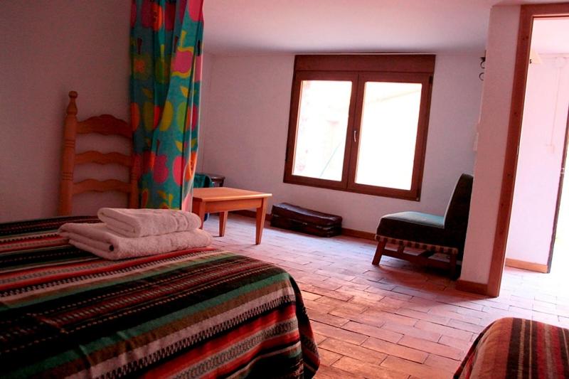 Un dormitorio con una cama y una silla y una ventana. en Casa Rural Nacimiento Rio Mundo, en Riópar