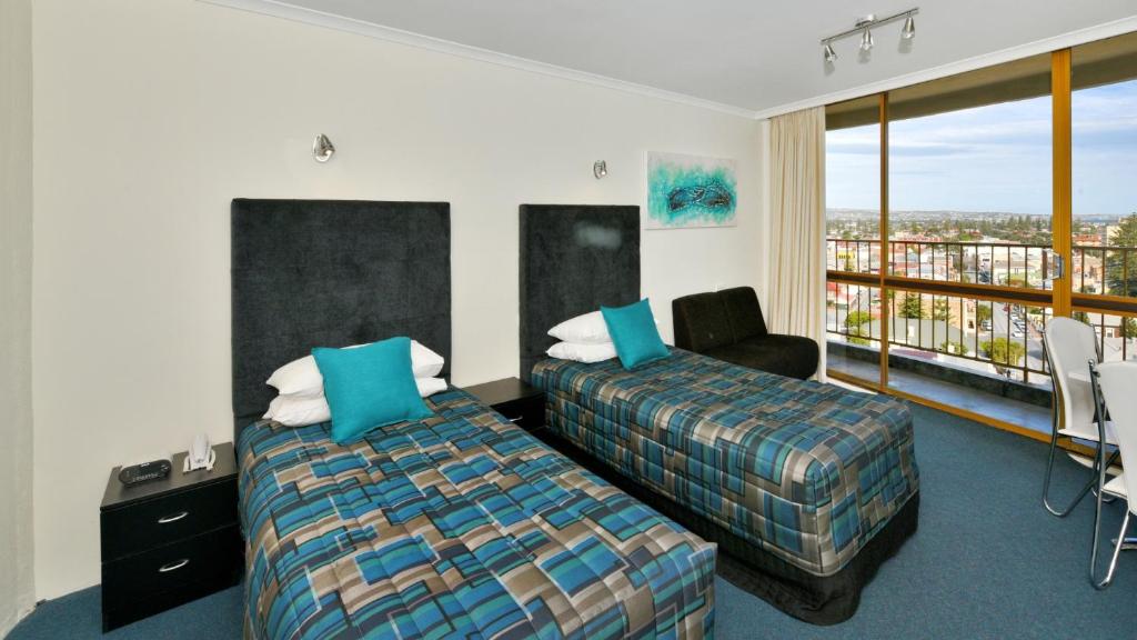 a hotel room with a bed and a balcony at Atlantic Tower Motor Inn in Adelaide