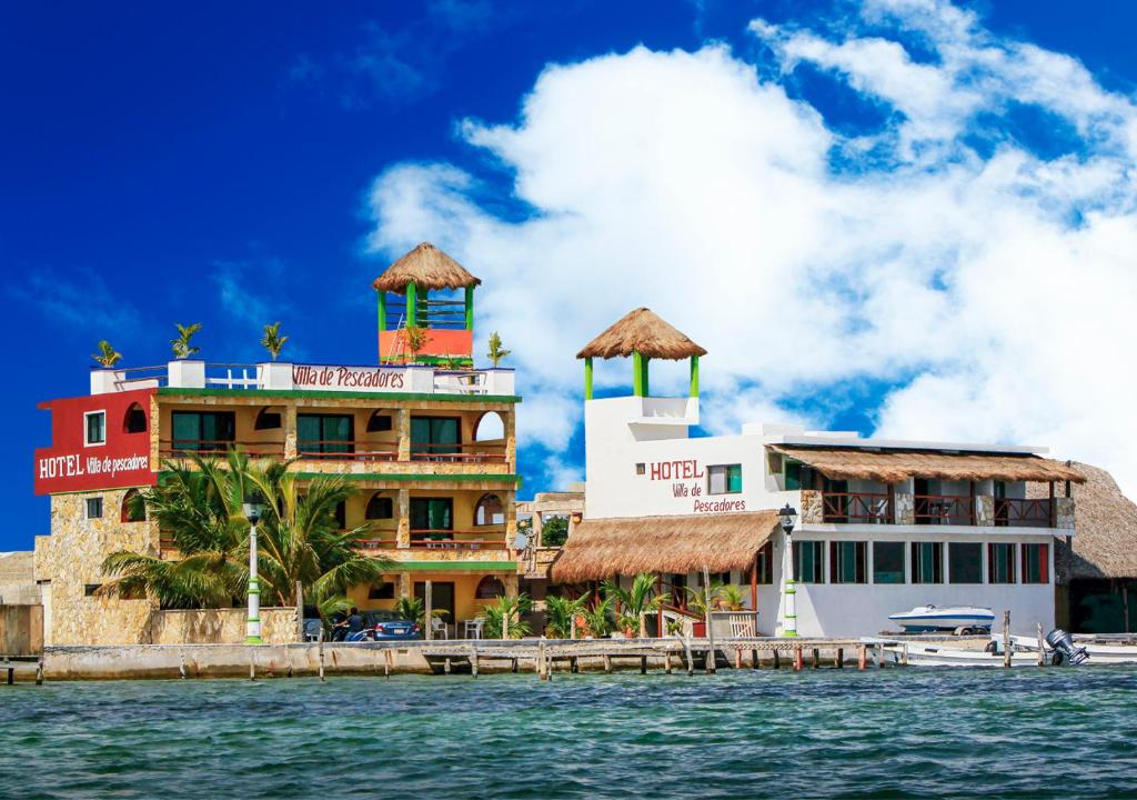 a building on the water next to the ocean at Hotel Villa de Pescadores in Río Lagartos