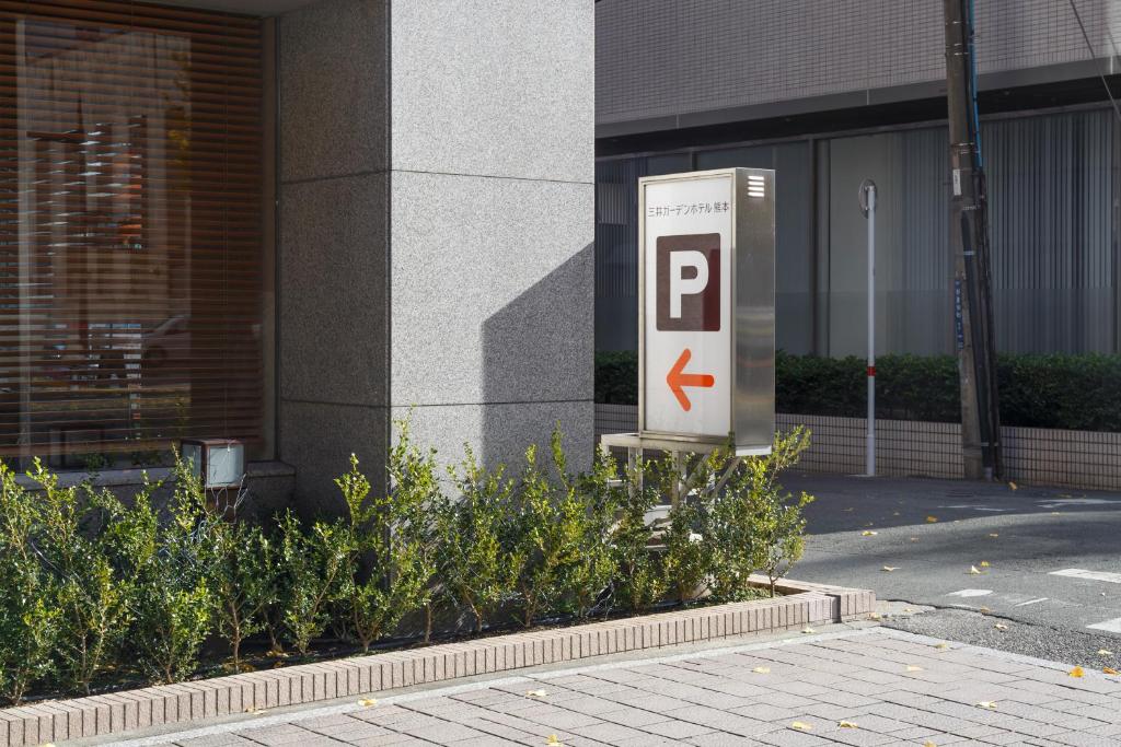 a parking sign in front of a building at Mitsui Garden Hotel Kumamoto in Kumamoto