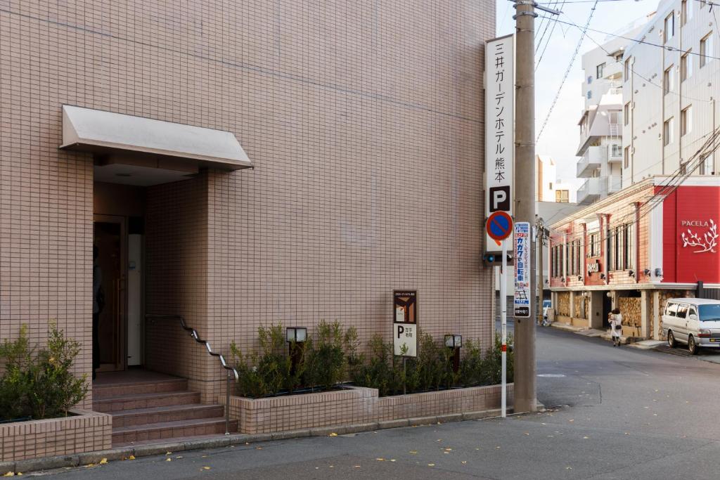 a building with a sign on the side of it at Mitsui Garden Hotel Kumamoto in Kumamoto