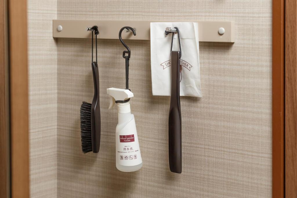 a toothbrush and a hair dryer hanging on a wall at Mitsui Garden Hotel Kumamoto in Kumamoto
