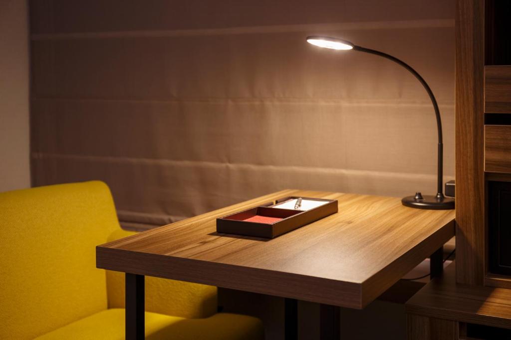 a desk with a lamp and a box on it at Mitsui Garden Hotel Kumamoto in Kumamoto