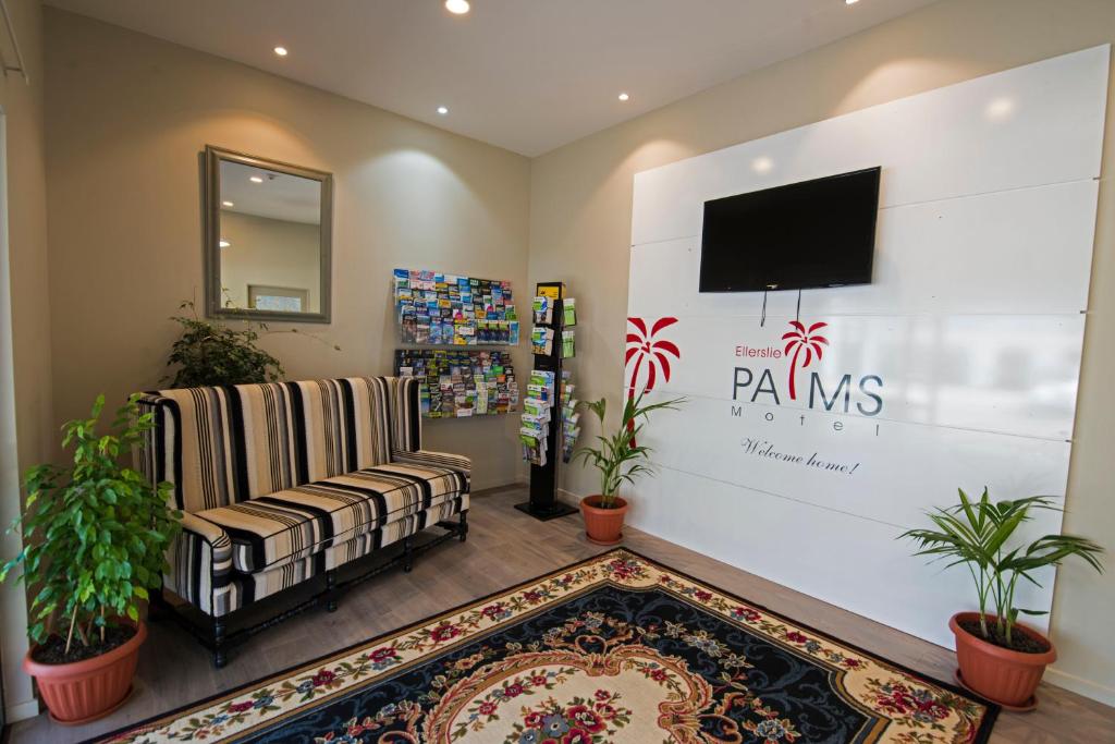 salon z telewizorem, kanapą i dywanem w obiekcie Ellerslie Palms Motel w Auckland