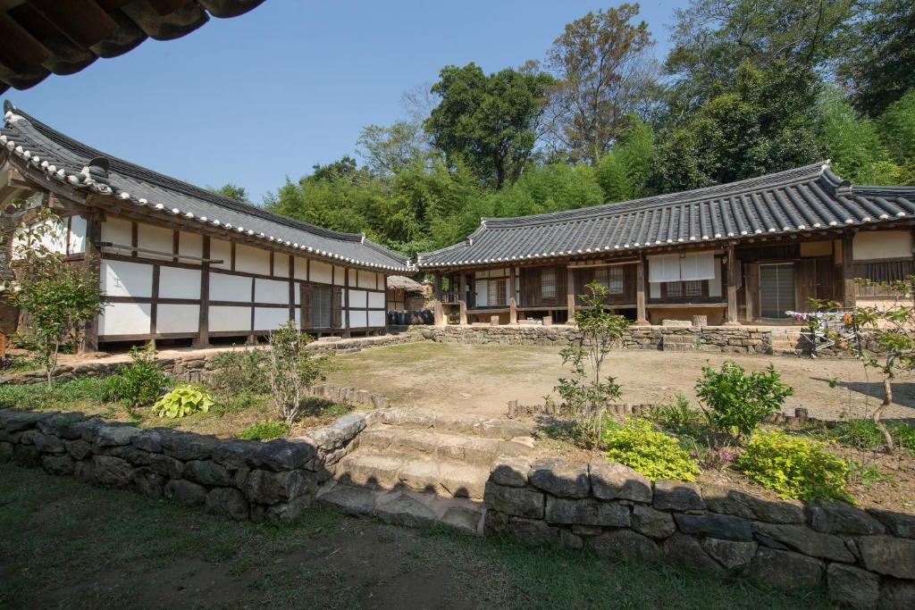 un edificio con un jardín delante de él en Jinrae Lee's Traditional House, en Boseong