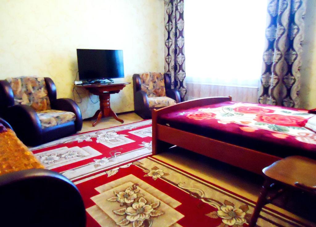 チタにあるApartment TwoPillows Krasnoarmeyskya 14 9flのベッドルーム(ベッド、椅子、テレビ付)