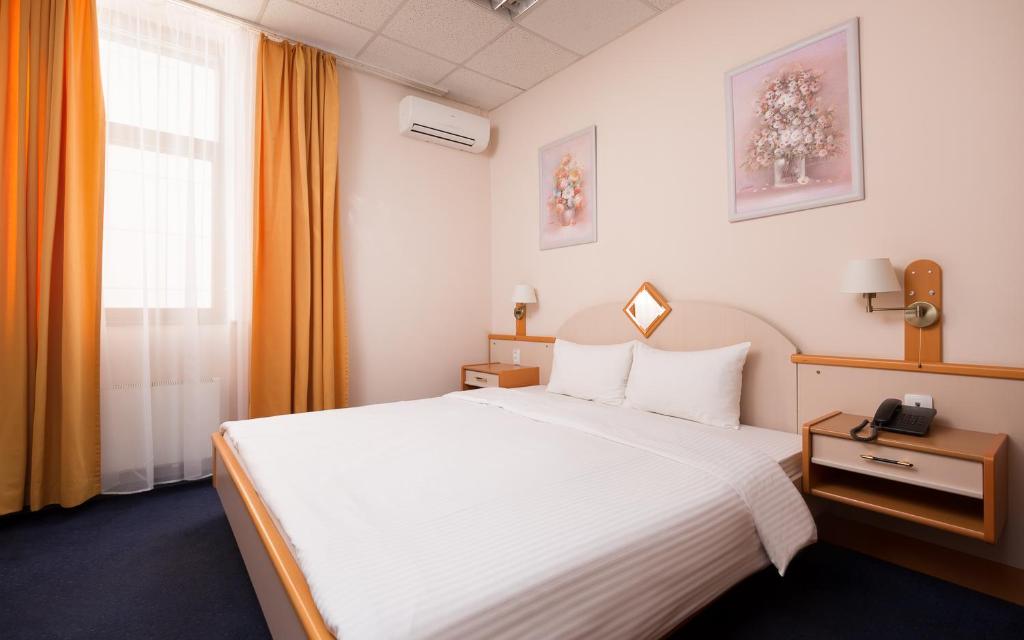 um quarto de hotel com uma grande cama branca e uma janela em TransHotel em Ecaterimburgo