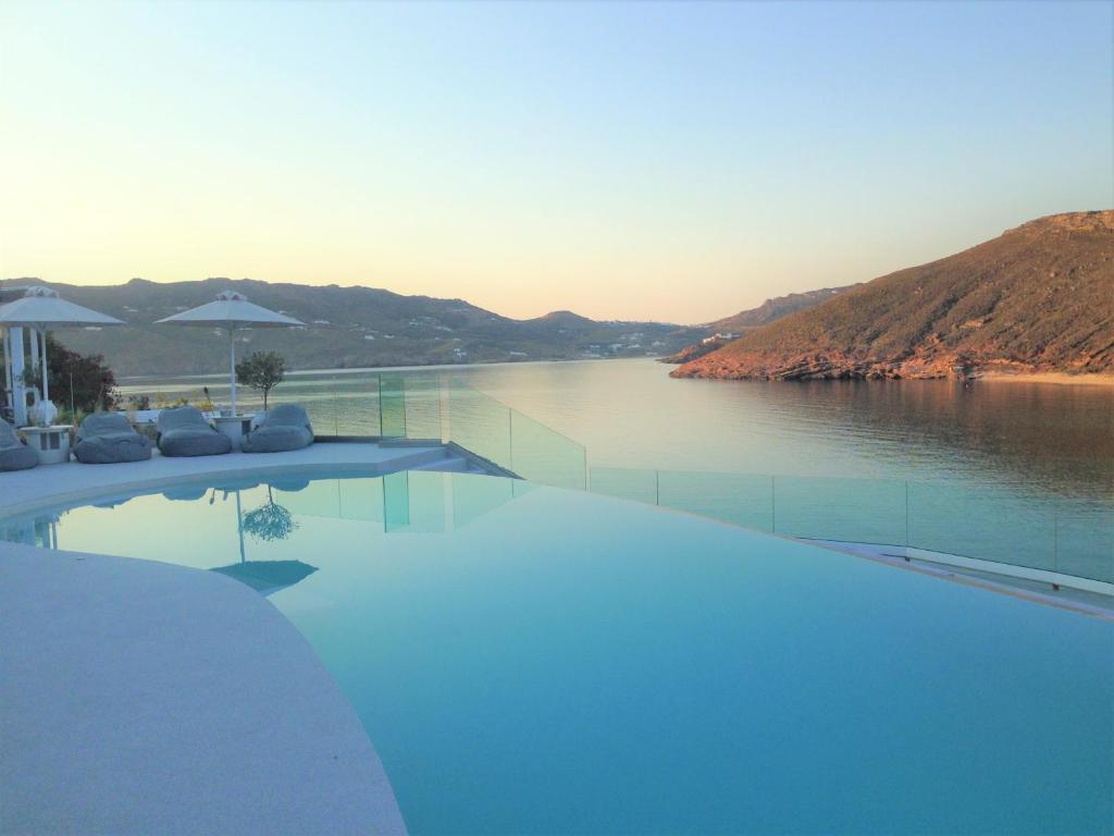 a swimming pool with a view of a body of water at Panormos Village Hotel in Mykonos