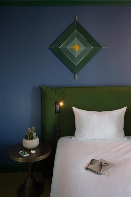 a bedroom with a bed and a table with a book on it at ibis Styles Paris Nation Cours de Vincennes in Paris