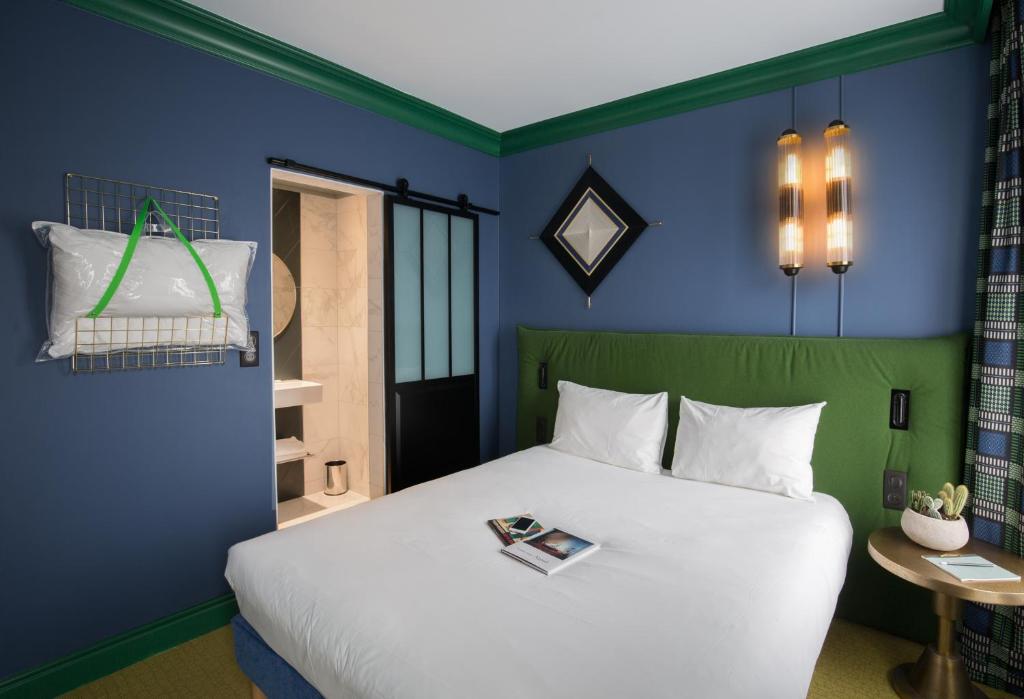 a bedroom with a large bed with blue walls at ibis Styles Paris Nation Cours de Vincennes in Paris