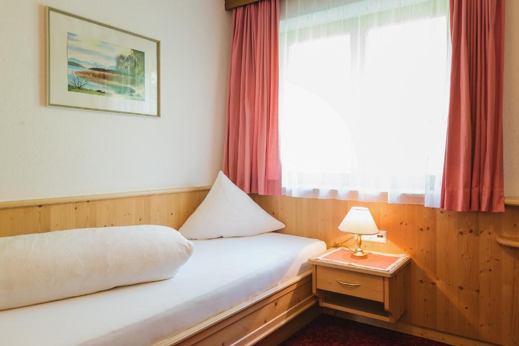 Postel nebo postele na pokoji v ubytování Hotel Garni Tirol