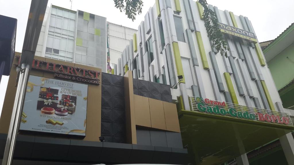 un bâtiment avec des panneaux sur son côté dans l'établissement MaxoneHotels.com at Kramat, à Jakarta