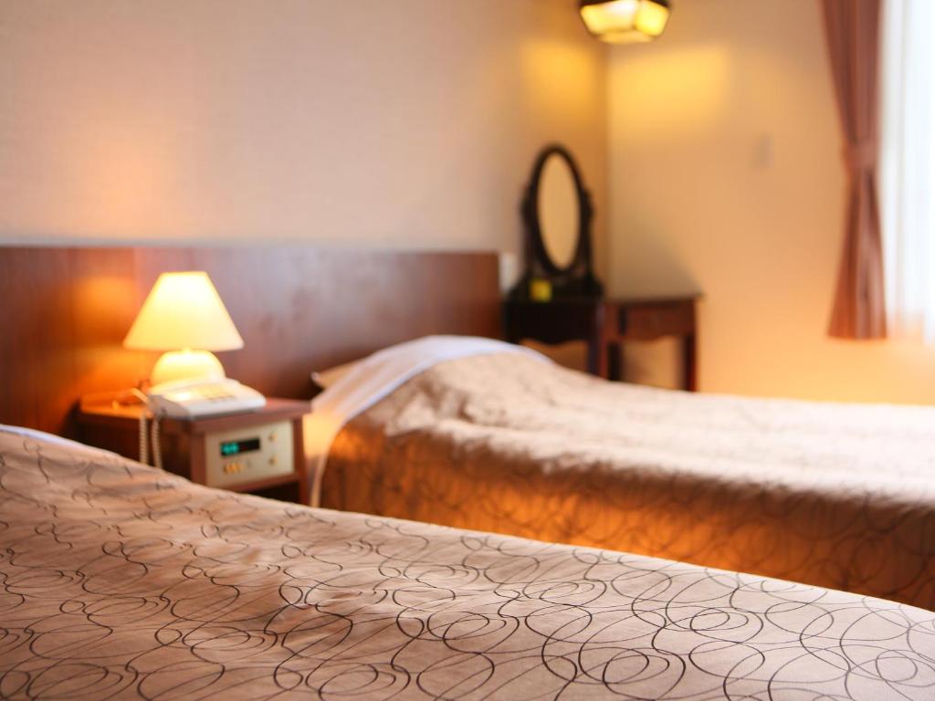 Postel nebo postele na pokoji v ubytování Hakuba Highland Hotel