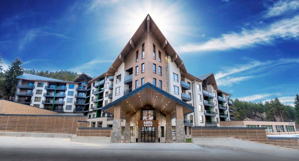 a large apartment building with a pointed roof at Hotel Arte SPA & Park in Velingrad