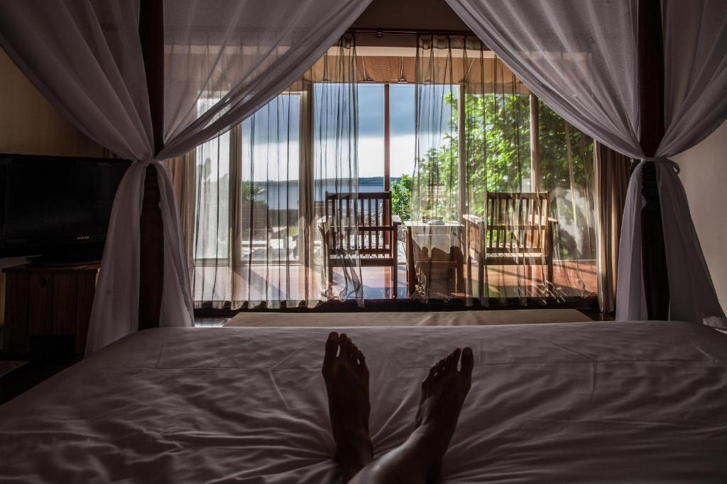 a person laying on a bed with their feet on the bed at Summer Ya B&amp;B in Huxi