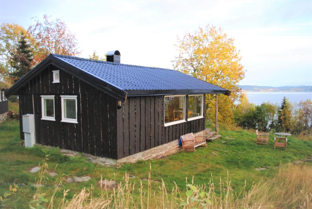 a black house with a solar roof on a field at Grindaplassen in Leksvik