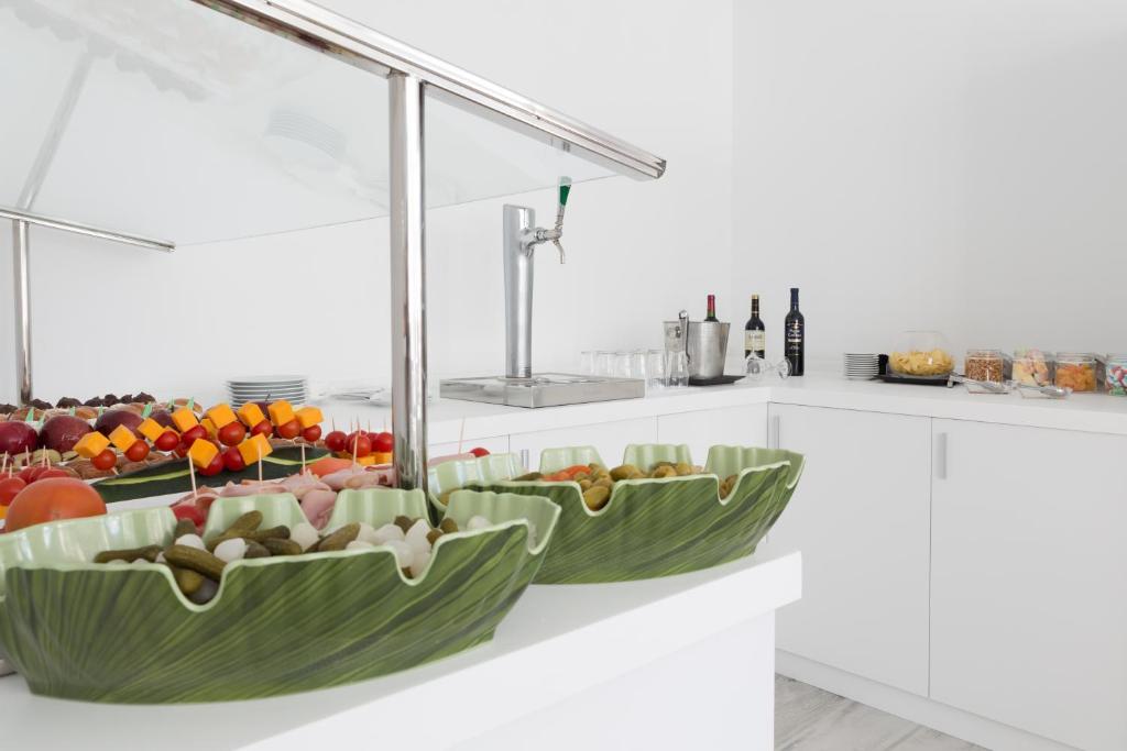 a kitchen with two green bowls filled with fruits and vegetables at Sandos Benidorm Suites in Benidorm