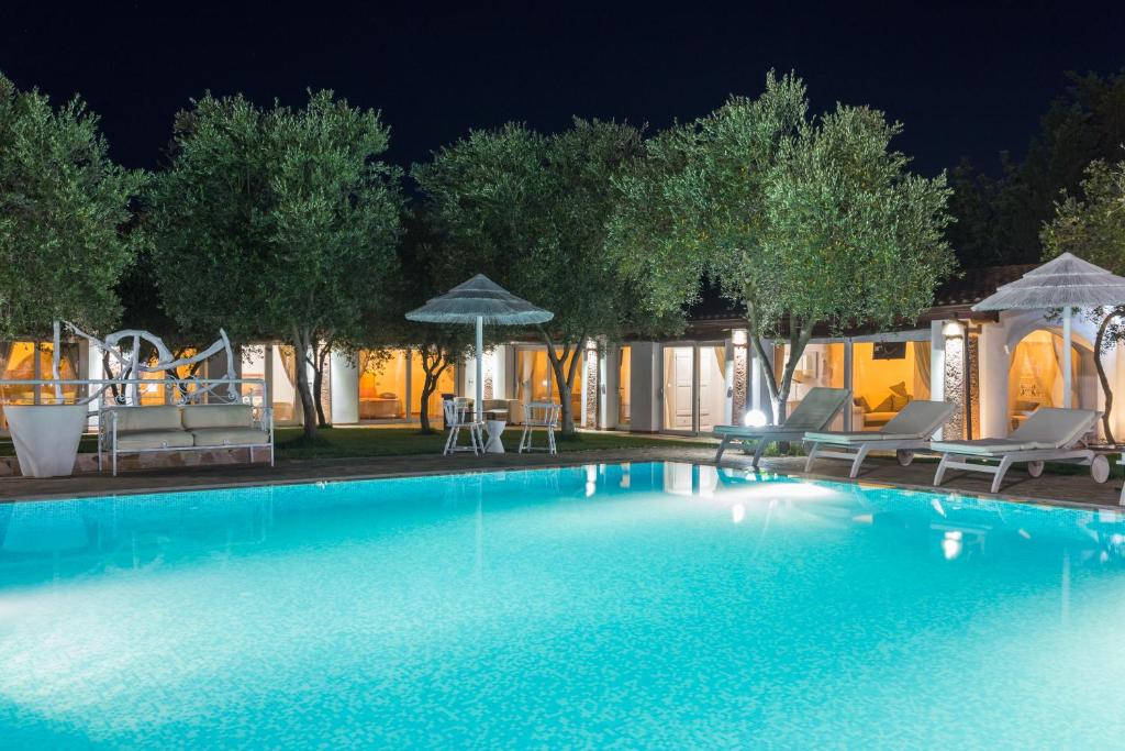 una piscina por la noche con sillas y sombrillas en Da Renzo, en Siamaggiore