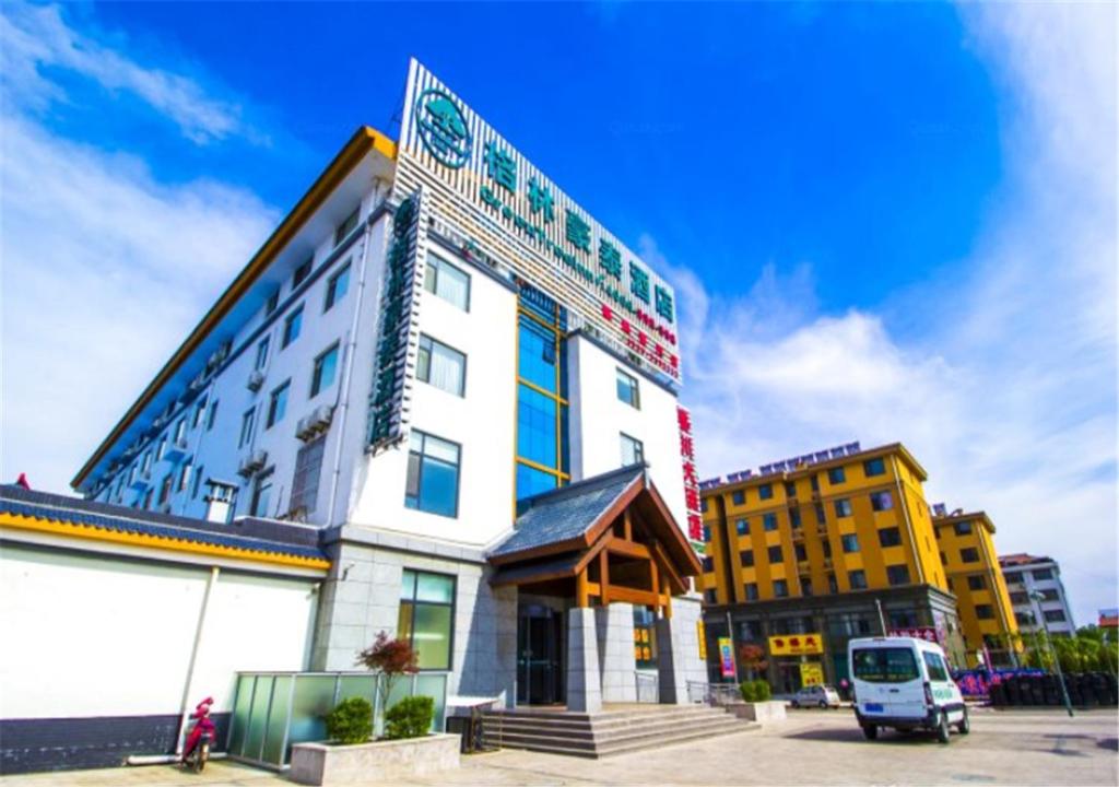 a building with a van parked in front of it at GreenTree Inn ShanDong WeiFang LinQu ZhanQian Road LuChuan Business Hotel in Linqu