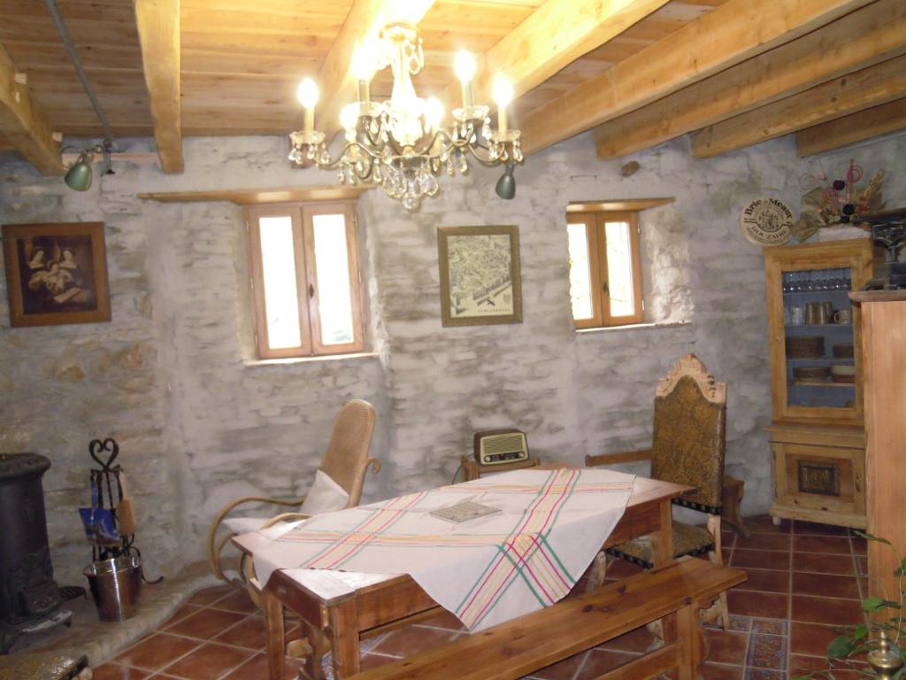 uma sala de jantar com uma mesa e um lustre em Les Citounelles em Citou