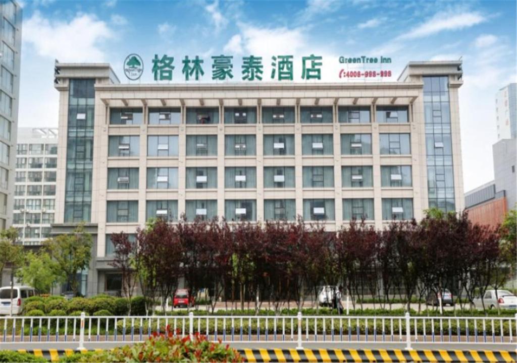 a large building with a sign on top of it at GreenTree Inn ShanDong RiZhao ShanHaiTian Holiday Resort Business Hotel in Rizhao
