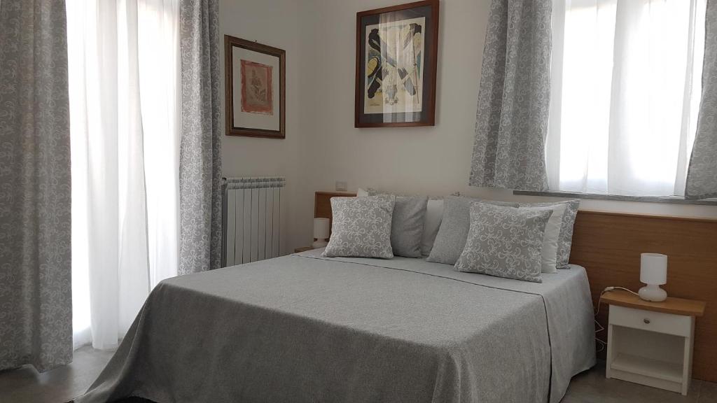 1 dormitorio con 1 cama con sábanas y almohadas blancas en Allegro Luxury B&B, en Rocca di Papa