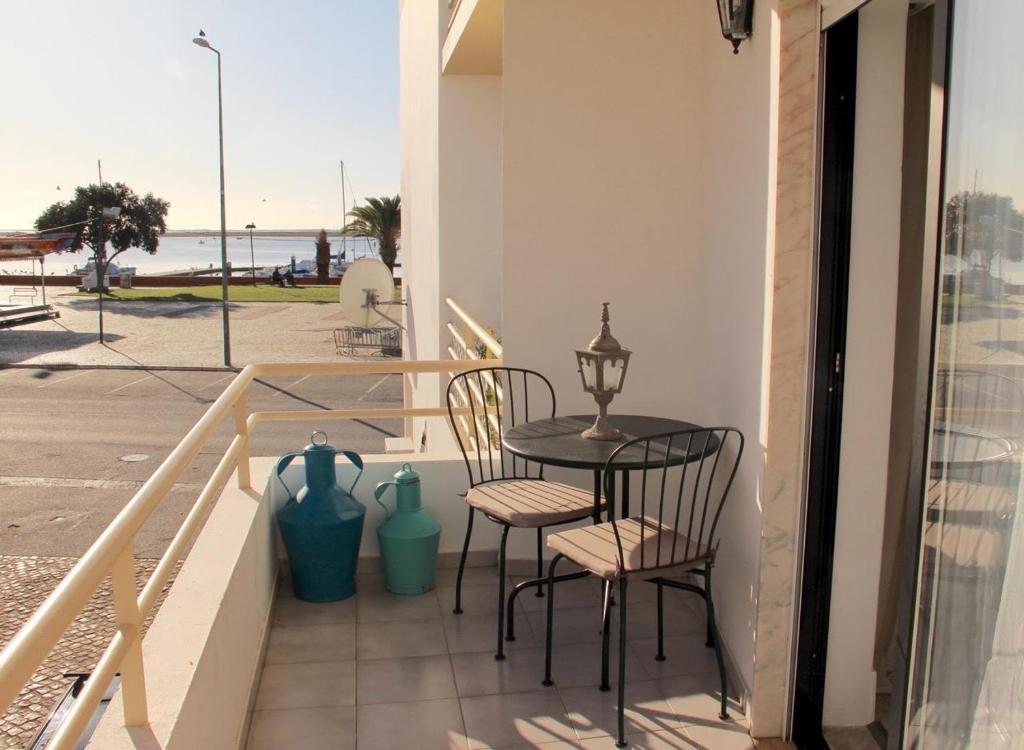 un tavolo e sedie su un balcone con vista sull'oceano di Casa Esti a Olhão