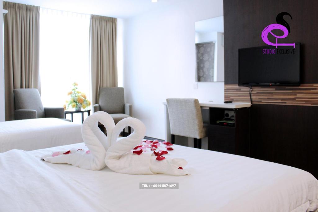 Dos cisnes con forma de corazón están en una cama en Studio Exclusive (Kota Bharu City Point), en Kota Bharu