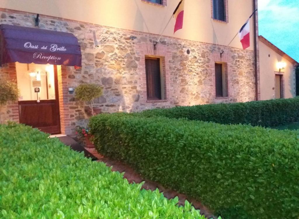 a building with a hedge in front of a building at Oasi Del Grillo in Castelnuovo Berardenga